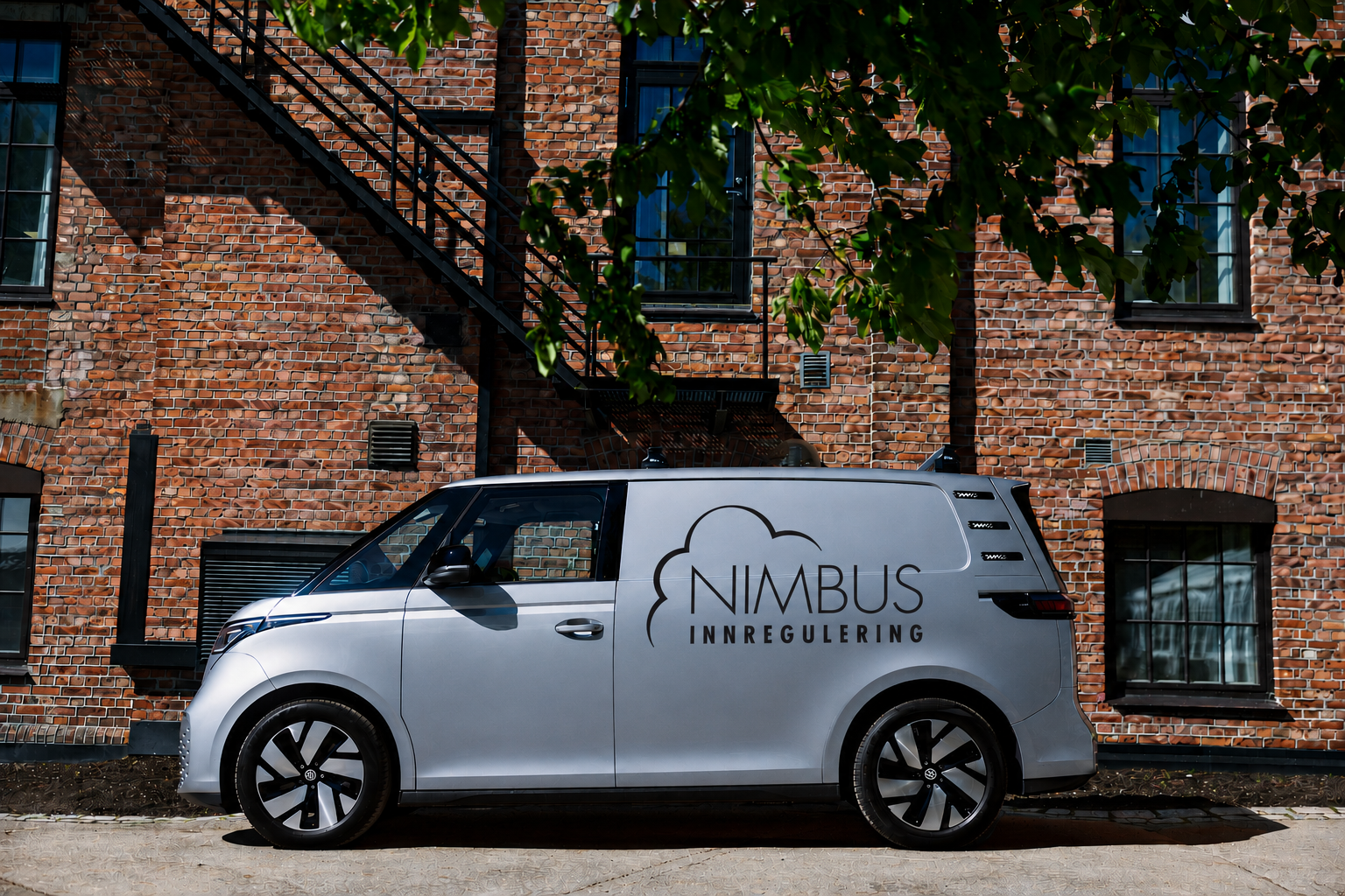 Nimbus Innregulering sin firmabil parkert foran et teglsteinsbygg